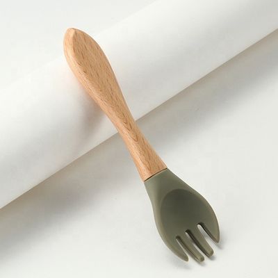 Produto as forquilhas e as colheres do silicone resistentes ao calor com punho de madeira