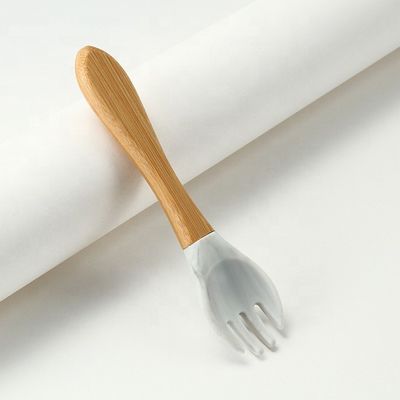Produto as forquilhas e as colheres do silicone resistentes ao calor com punho de madeira