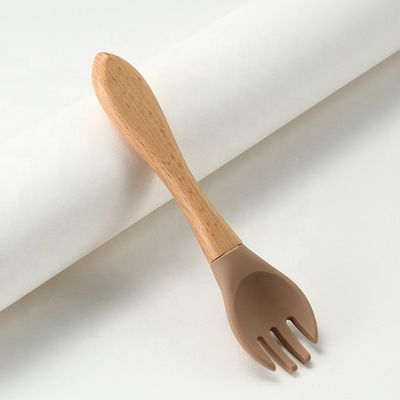 Produto as forquilhas e as colheres do silicone resistentes ao calor com punho de madeira